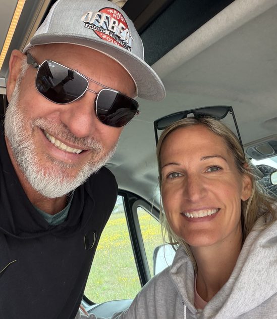 Tod Hirsch and his wife Sarah smiling inside a van on a road trip