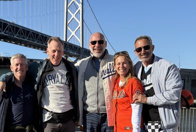 Tod Hirsch with high school friends at a San Francisco Giants game, the Bay Bridge behind them